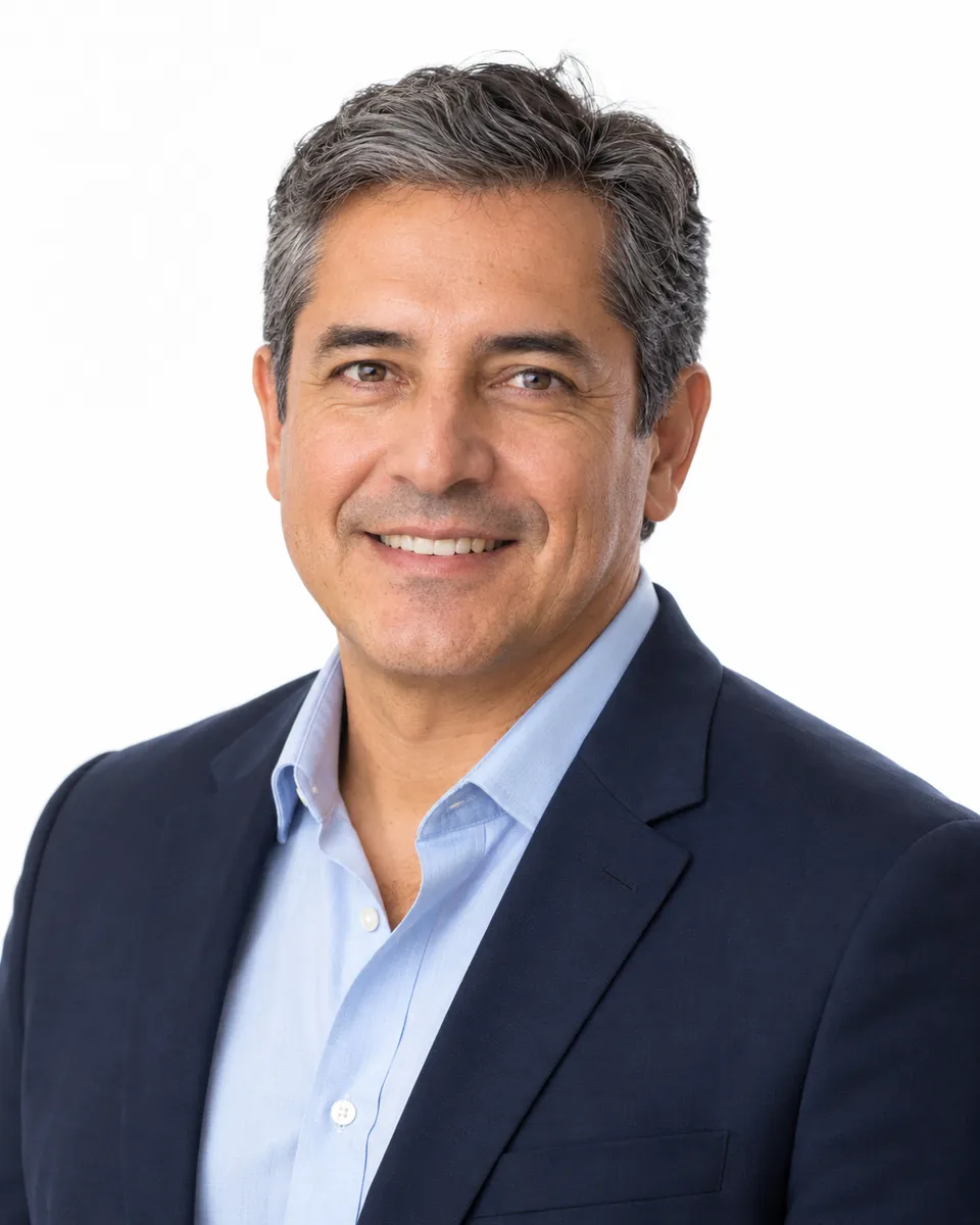 Retrato profesional de un hombre con saco azul sobre fondo blanco para LinkedIn.